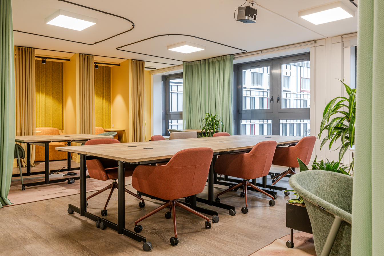 Plateau principal des Ateliers Lill'loi : open space modulable, alcôves à rideaux, fauteuils terracotta et végétalisation, baies vitrées donnant sur Lille.